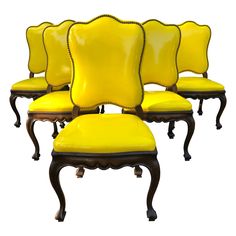 six yellow chairs with black legs and back rests on each other in front of a white background