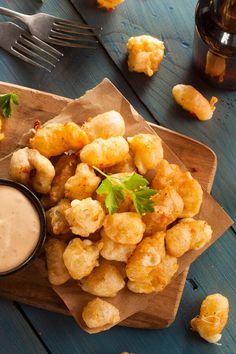 some fried food is sitting on a plate with a dipping sauce in the middle and garnished with parsley