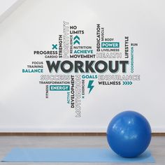 a blue exercise ball sitting on top of a yoga mat in front of a white wall