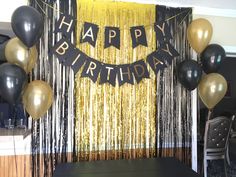 a birthday party with black and gold balloons, streamers, and tassels