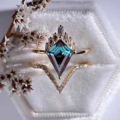 a blue diamond ring sitting on top of a white plate