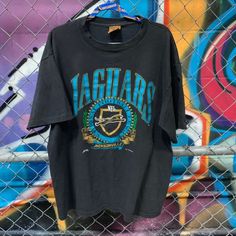 Vintage 1993 Jacksonville Jaguars T Shir shirt Shipping from the US. Easy 30 day return policy, 100% cotton, Double-needle neck, sleeves and hem; Roomy Unisex Fit. 90s Style Letter Print Top For Fans, 90s Letter Print Top For Fan Merchandise, 90s Style Tops With Letter Print For Fans, Throwback Black Short Sleeve Top, 90s Style Logo Print Fan Merchandise Tops, 90s Logo Print Tops For Fans, 90s Logo Print Tops For Fan Merchandise, 90s Style Logo Print Tops For Fans, 90s Style Tops With Logo Print For Fans