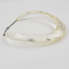 This is part of Chairish’s Costume Jewelry assortment.  An elegant Italian artisan designer studio collar choker necklace.  Lucite or resin rigid bib shape in translucent clear color ornate with silver flakes inclusions in an organic abstract free-form design. Silvered metal chain to adjust the length. No visible maker's mark. Measurements: The inner circumference is 16.57 in (42 cm) - the front height is 1 in (2.6 cm) - the opening is 3.38 in (8.5 cm) - the necklace will fit an average 14.57 in Elegant Resin Necklaces For Party, Clear Lucite Party Jewelry, Elegant White Resin Necklace, Formal Clear Lucite Jewelry, Elegant Lucite Jewelry For Formal Occasions, Elegant Clear Resin Jewelry, Elegant Resin Jewelry For Wedding, Transparent Resin, Choker Collar