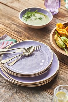 there are plates and bowls with silverware on the table next to eachother