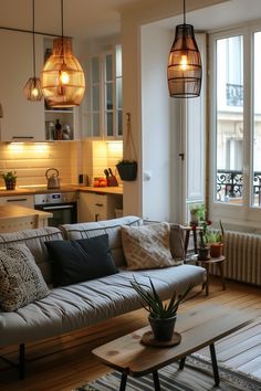 a living room filled with furniture next to a window covered in light fixture shades and hanging lights