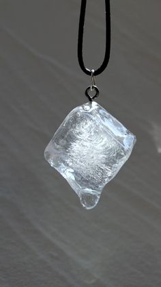 an ice cube hanging from a black cord