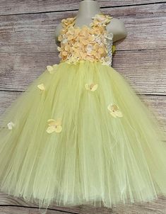 This adorable and beautiful dress is hand-made by Stella with full of love and affection and is perfect for your lovely girl for her birthday, being a flower girl, for the wedding party, being bridesmaid, for the christening, or any other special occasion. The dress features 6-inch-long soft crochet which is completely covered with beautiful yellow flowers that are scattered over the skirt and extending onto the shoulder straps. The matching satin shoulder straps are adjustable and tie into a bo Whimsical Tulle Tutu Dress For Garden Party, Sweet Spring Princess Dress For Wedding, Cute Tulle Fairy Dress For Spring, Birthday Dress With Floral Applique In Tulle, Cute Spring Fairy Dress Made Of Tulle, Sweet Spring Princess Wedding Dress, Whimsical Spring Wedding Fairy Dress, Sweet Spring Wedding Princess Dress, Cute Floral Applique Dress For Birthday