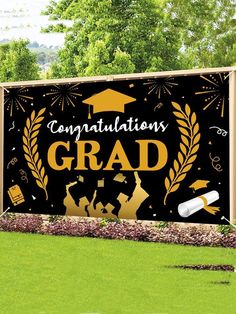 congratulations grad banner with graduation cap and diploma on it in front of a grassy field