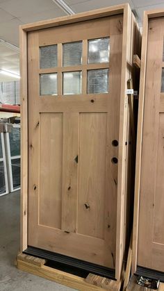 two wooden doors sitting side by side in a warehouse