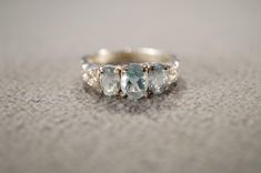 I am offering you this vintage sterling silver  wedding band stacker design ring. It features 3  total oval shaped prong set genuine faceted blue topaz stones.  These stones are set in a raised relief multi stone setting. There is fabulous raised relief design work here. It is measuring app. 3/4 inch, by app. 1/4 inch.  It is currently a size, 6.5 .   Though  I am sure it could be sized up or down. It weighs app. 5 grams.  Look at the detail of the design work of this vintage ring Simply breatht Classic Three-stone Topaz Ring For Wedding, Classic Three Stone Topaz Ring For Wedding, Classic Three Stone Topaz Wedding Ring, Three Stone Topaz Ring For Wedding, Three Stone Blue Topaz Jewelry For Wedding, Aquamarine Three-stone Wedding Rings, Aquamarine Three Stone Wedding Rings, Sterling Silver Three Stone Topaz Wedding Ring, Sterling Silver Topaz Three Stone Wedding Ring