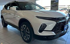 a white chevrolet suv parked in a showroom