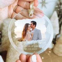 a person holding up a glass ornament with a photo on the front and side