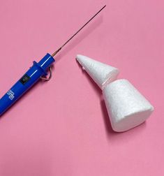 an electric toothbrush and cotton swab next to each other on a pink surface