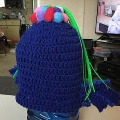 a blue crocheted hat with pom - poms on it's head