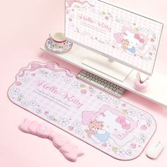 a pink mouse pad and keyboard on a desk next to a computer monitor with hello kitty stickers