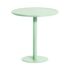 a small round table with a light green color on the top and bottom, sitting in front of a white background