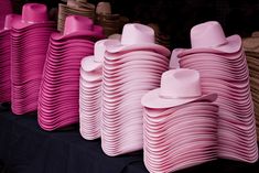 many pink hats are stacked on top of each other in rows, with one hat sticking out of the middle