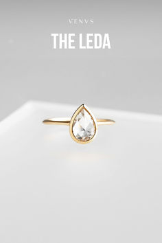 The Leda ring in 14k yellow gold with a bezel set 1.29ct pear cut moissanite. Shop all ready-to-wear Leda engagement rings or custom design your own at www.shopvenvs.com.