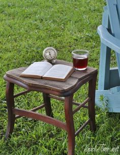 an open book on a small wooden table with a cup of tea next to it