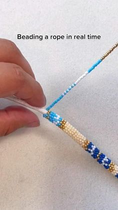 a person is making beading a rope in real time with beads and thread on the end