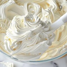 a bowl filled with white frosting on top of a table