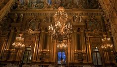 an ornate room with chandeliers and paintings on the walls