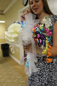 a woman holding a bouquet of colorful ribbons