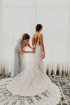 two bridesmaids helping each other get ready for their wedding at the hilton hotel