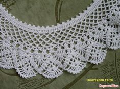 a white crocheted collar is laying on a piece of cloth with the words,'free pattern'written below it