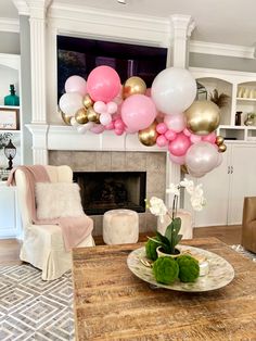 a living room filled with furniture and balloons in the air over a fire place mantle