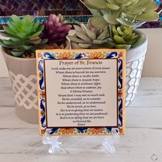 a plaque sitting on top of a table next to a pot filled with succulents