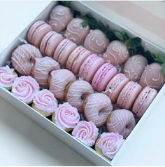 a box filled with lots of pink macaroons