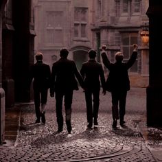 three men walking down the street holding hands