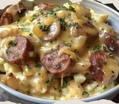 a bowl filled with pasta and sausage covered in cheese