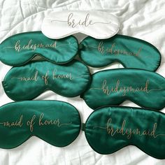 six bridesmaid sleep masks with gold lettering on them, all lined up together