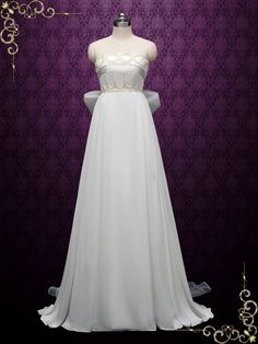 a white wedding dress on display in front of a purple wall