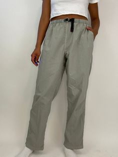 Vintage 00s pants by Gramicci grey nylon with an adjustable waist and built in belt. USA made. Label: Gramicci Material: nylon Condition: excellent vintage condition Labeled as size XL but please see measurements. Measurements lying flat, double the armpit, waist, and hips. Waist: 15.5" Hips: 26" Inseam: 31" Rise: 13" Techwear Gray Bottoms For Outdoor Activities, Functional Parachute Pants With Belt Loops For Outdoor, Gray Parachute Pants With Cargo Pockets For Outdoor, Gray Techwear Parachute Pants For Outdoor, Gray Utility Pants For Outdoor Activities, Khaki Parachute Pants With Belt Loops For Outdoor Activities, Khaki Parachute Pants With Belt Loops For Outdoor, Utility Parachute Pants With Elastic Waistband For Hiking, Sporty Khaki Parachute Pants For Outdoor Activities