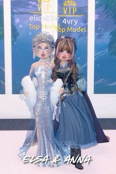 two dolls are posed in front of a sign