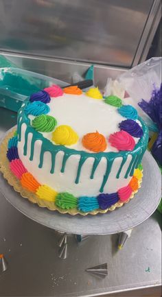 a cake with white frosting and rainbow colored icing