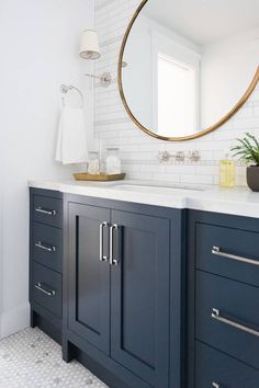 a white and blue bathroom with a round mirror