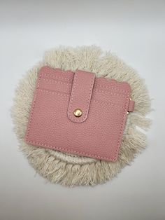 a pink purse sitting on top of a white fur covered floor