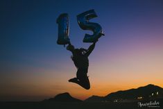 a person jumping up into the air with a number 15 balloon