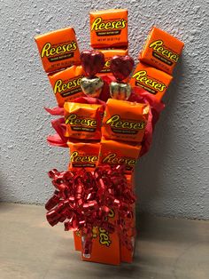 a bouquet of reese's candy wrapped in red ribbon and tied to a wall