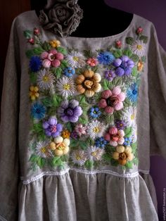 a woman's top with flowers on it and a flower in the middle of the shirt