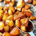 some food that is on top of a pan with spoons in it and potatoes