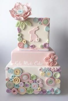 a three tiered cake with buttons and flowers on it's side, decorated in pastel colors