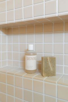 a soap bar sitting on top of a white tiled counter next to a block of soap