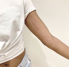 a woman's arm with a small tattoo on the left side of her arm