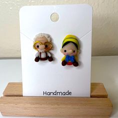 two little cartoon characters sitting on top of a white card with the words handmade