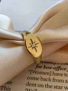 a ring with a star on it sitting on top of an open book